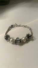 Silver tone charm bracelet w/ black & white a...