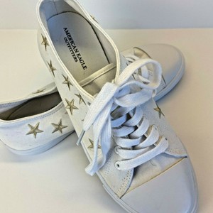 white sneakers with gold stars