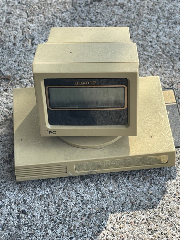 A desk clock disguised as a floppy disk that hides a pull-out calculator — the most gloriously over-engineered 90s office gadget imaginable.