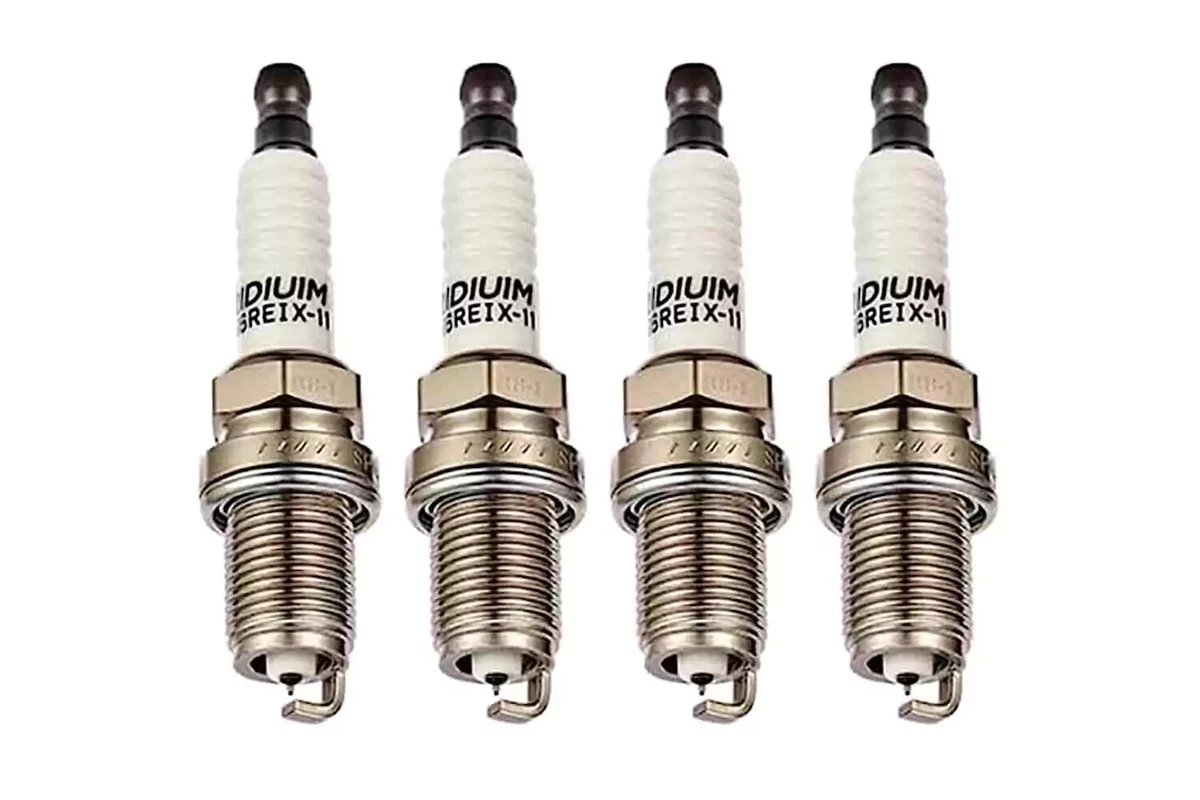 A set of four iridium spark plugs, displayed on a white background.