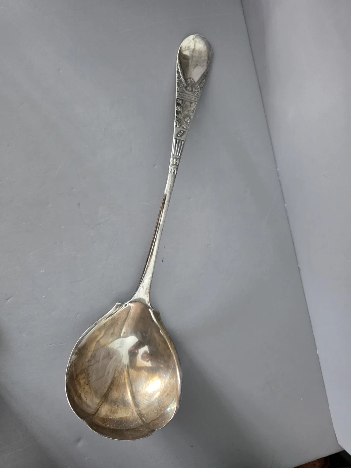 Ornate silver-plated serving ladle with Designed scrollwork handle. 14"