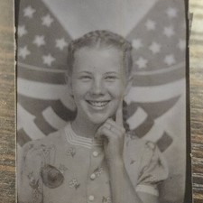 Cabina de fotos vintage en blanco y negro joven sonriente con lazo patriótico trasero cabello trenzado