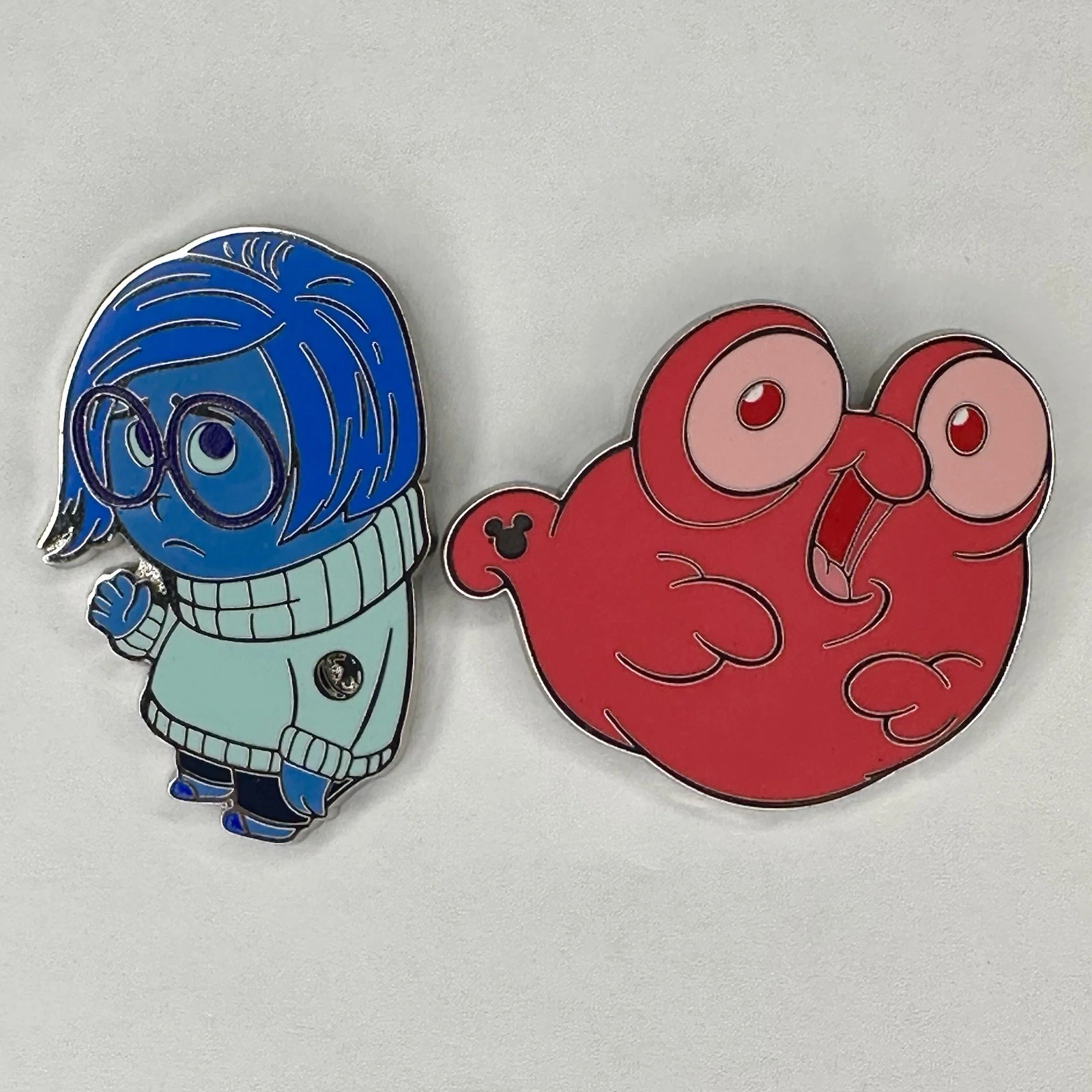 Disney 2025 Hidden Disney Pins - Sadness (Blue Story) & Morph (Pink Story)