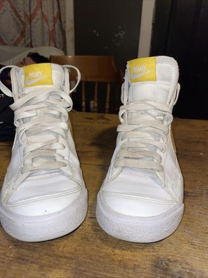 ike Blazer Mid '77 sneaker in white with an Optic Yellow Swoosh logo.  