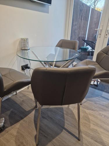 Round Glass dining table with four grey chairs - Picture 4 of 5