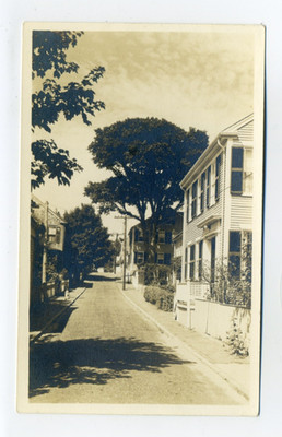 Nantucket MA, narrow lane by homes, car in distance, RPPC postcard