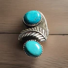 Vintage Navajo sterling silver ring with two turquoise stones and feather motif.