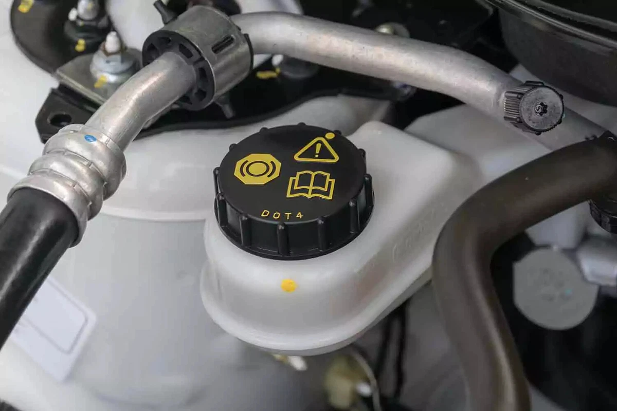 Close-up view of a clutch fluid reservoir in a vehicle requiring DOT4 brake fluid.