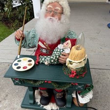 Estatuilla de Navidad de Papá Noel con mesa verde, muñeca elfa, paleta de pintura, vela