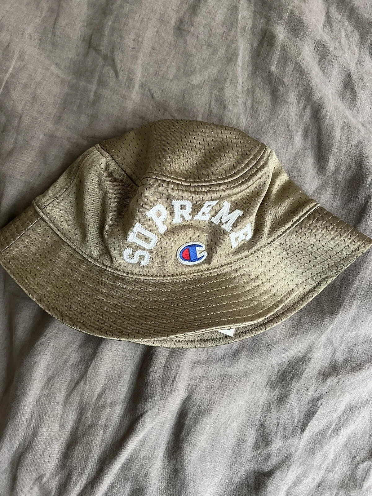 Chapeau seau concasseur en maille Supreme x Champion S/M bronzage livraison gratuite rapide ?