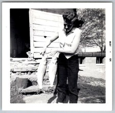 Vtg B&W Snapshot Woman Holding Two Large Fish Outside Rustic Wood Cabin May 1964