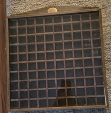 vintage wooden thimble display case with 100 compartments and a glass cover.