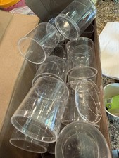 Box full of clear plastic round empty cylindrical containers