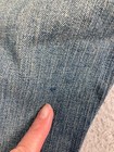 Close-up of blue denim fabric with fine textured weave, slightly faded wash, and “Karen Kane Lifestyle Jeans” tag.