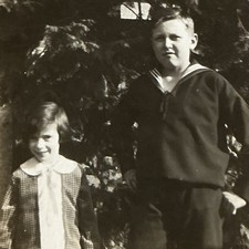 Junge im Matrosenanzug steht mit Schwester Mädchen im Garten Geschwister Foto