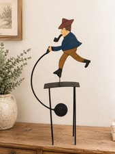 Vintage Tin Man with a pipe on a teeter totte...