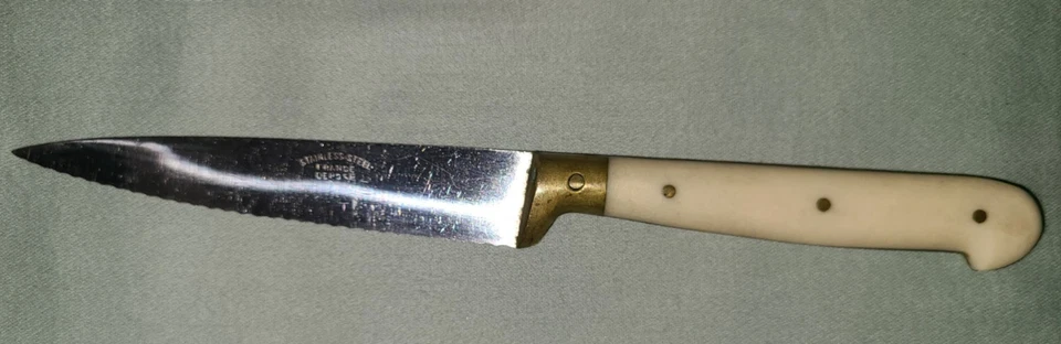 Vtg serrated stainless blade steak knife w white Bakelite? handle, France depose