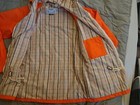 Orange ribbed trim and drawstrings, beige interior lining with yellow chest pocket, made in USA.