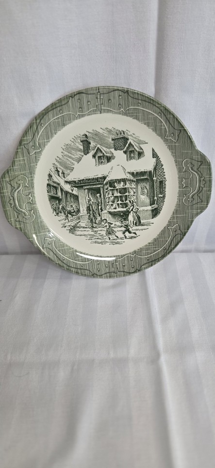 A genuinely charming piece of Americana — a green-glazed vintage cake plate with handles that looks straight out of a grandmother's china cabinet in the best possible way.