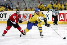 Paul di Pietro of Switzerland tries to hook Jonas Hoglund in- Ice Hockey Photo