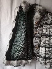 Pelliccia animalier bianca. Modello dritto, ai fianchi. Abbottonatura alamari.