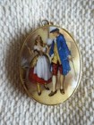 Oval geformter ANHÄNGER..bemalte Szene von Mann & Frau in Kolonialkleidung..goldfarben