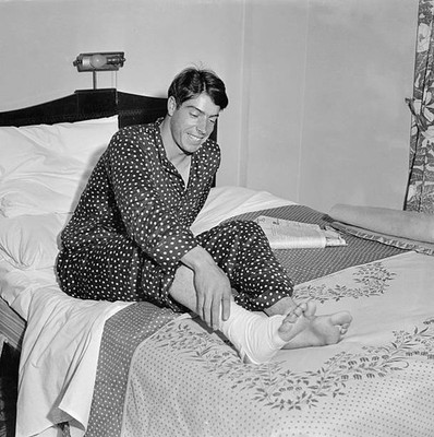 Joe DiMaggio tries to grin despite his pain as he nurses torn muscl- Old Photo