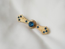Decorative brooch with blue glass stone.
