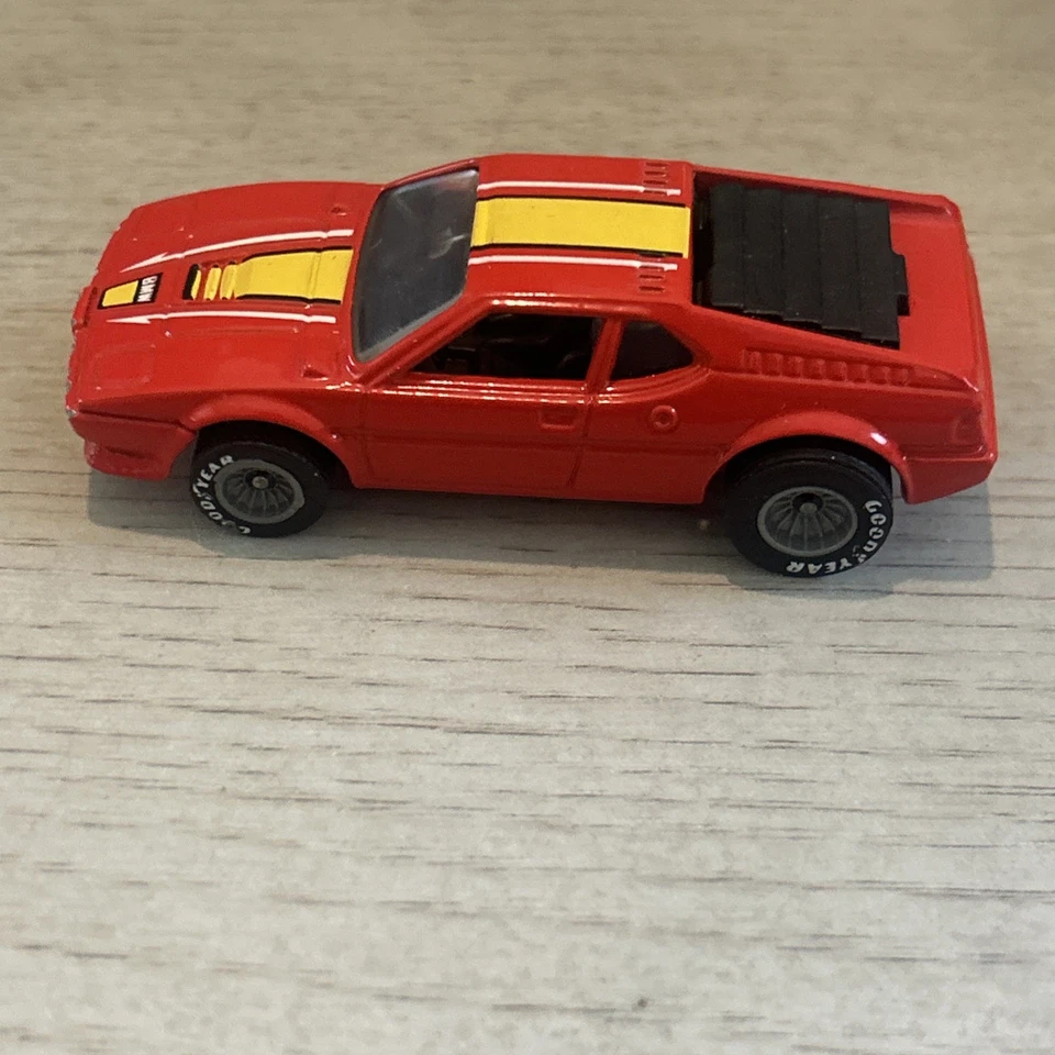 Coche diecast Hot Wheels BMW M-1 Real Riders 1982 rojo con rayas amarillas Malasia Foto 2 de 4
