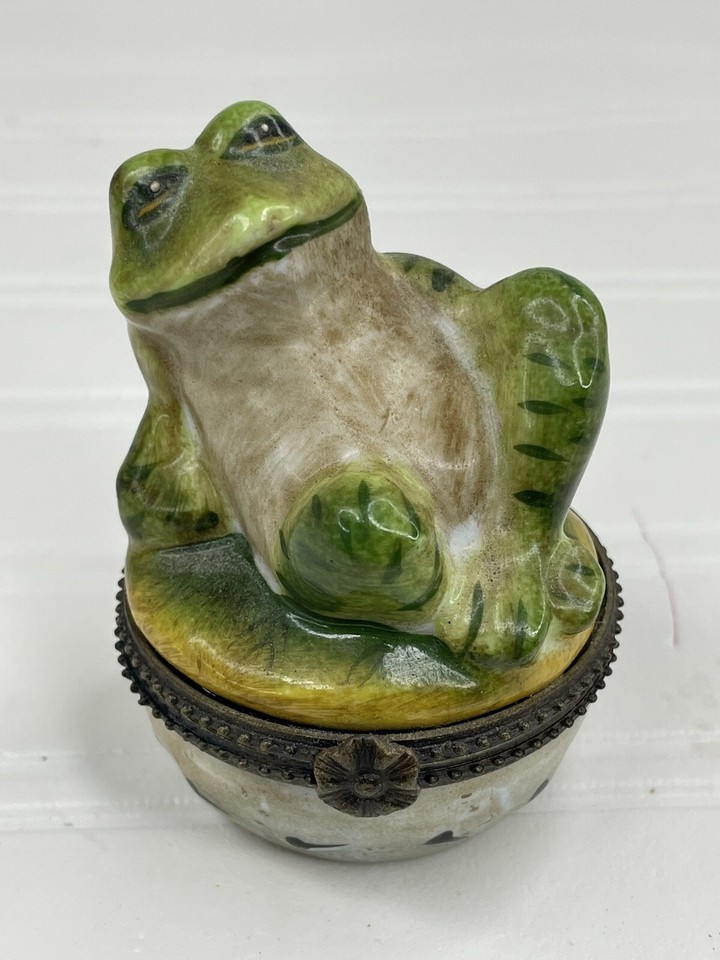 A reclining porcelain frog hiding a secret compartment — vintage kitsch at its most charming and giftable.