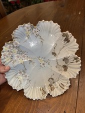 A Limoges-style porcelain plate with hand-painted florals and gilded rim.