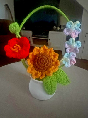 Gemütlicher gehäkelter Blumenkorb im weißen Topf. Handarbeit Häkelblumen