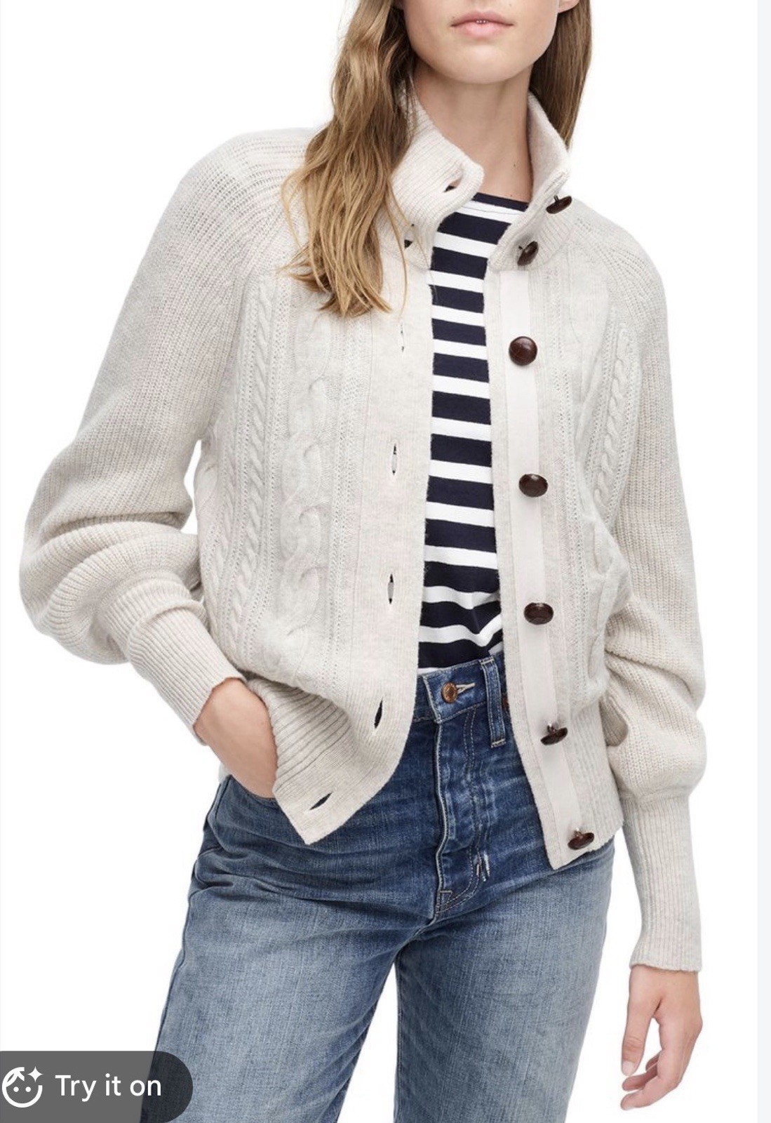 Oatmeal cable-knit lambswool cardigan with balloon sleeves, folded flat.