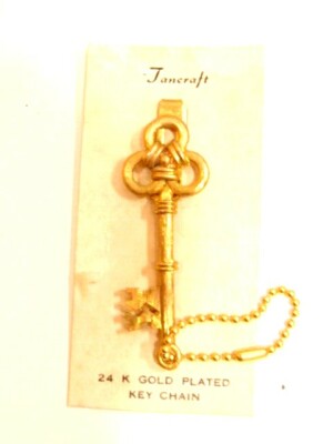 older unused gold color ''key'' shaped key chain on old store display card