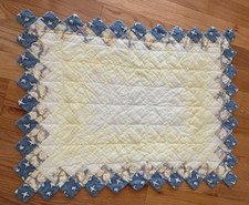 Quilted table topper handmade, light yellow with a blue trim, liner on the back