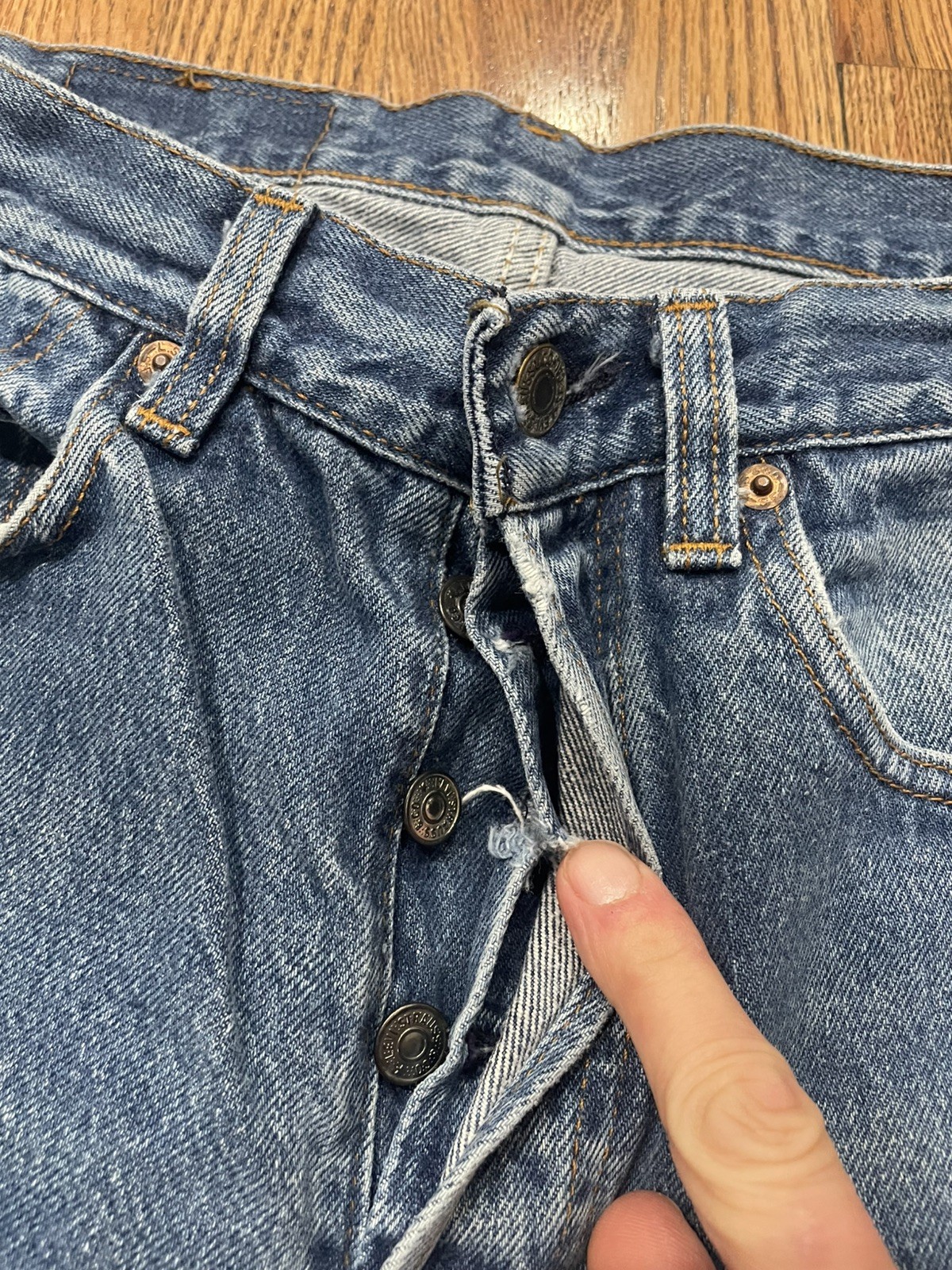 Vintage Levi’s 501XX blue denim with silver rivets, button closure, and “Made in U.S.A.” tag on waistband.