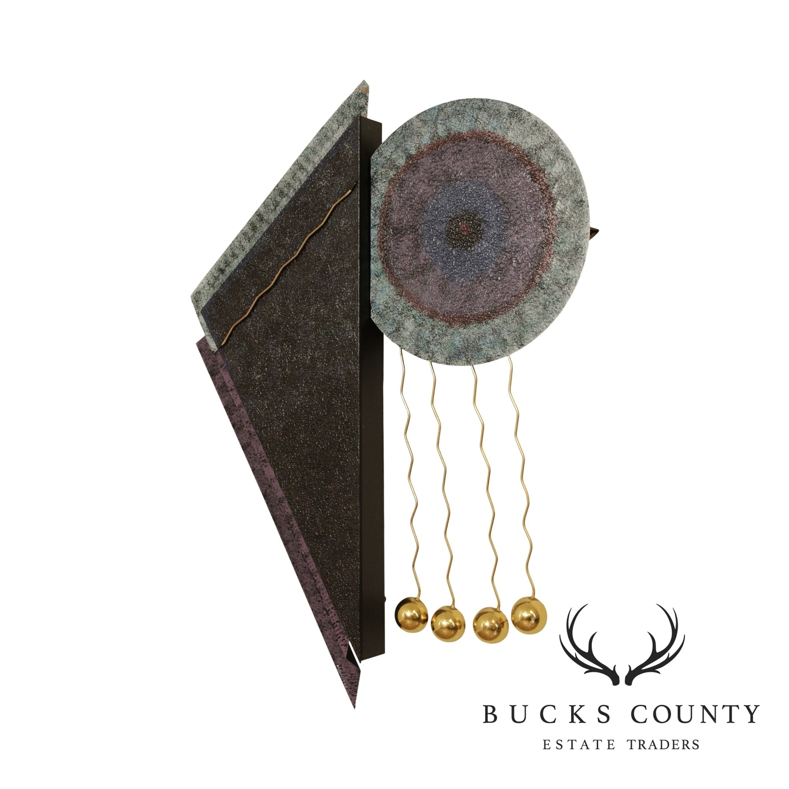 Wall sculpture with a large textured triangular panel in dark bronze and mauve tones beside a round mottled disc, with brass wire pendulum balls hanging below.