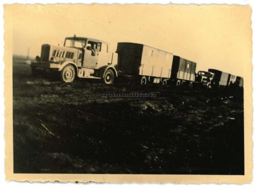 Original. Foto tractor de ruedas tractor de ruedas con dos remolques vagón camión en el barro - Imagen 1 de 1