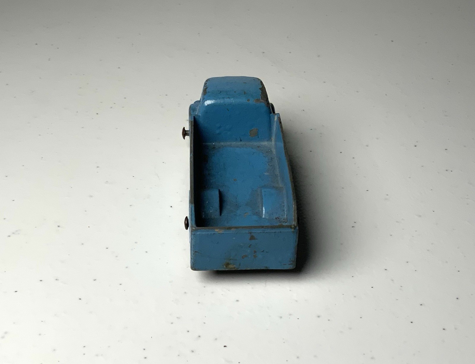 Blue vintage Tootsietoy #234 box truck with worn metal parts and visible “Made in U.S.A.” text on top.