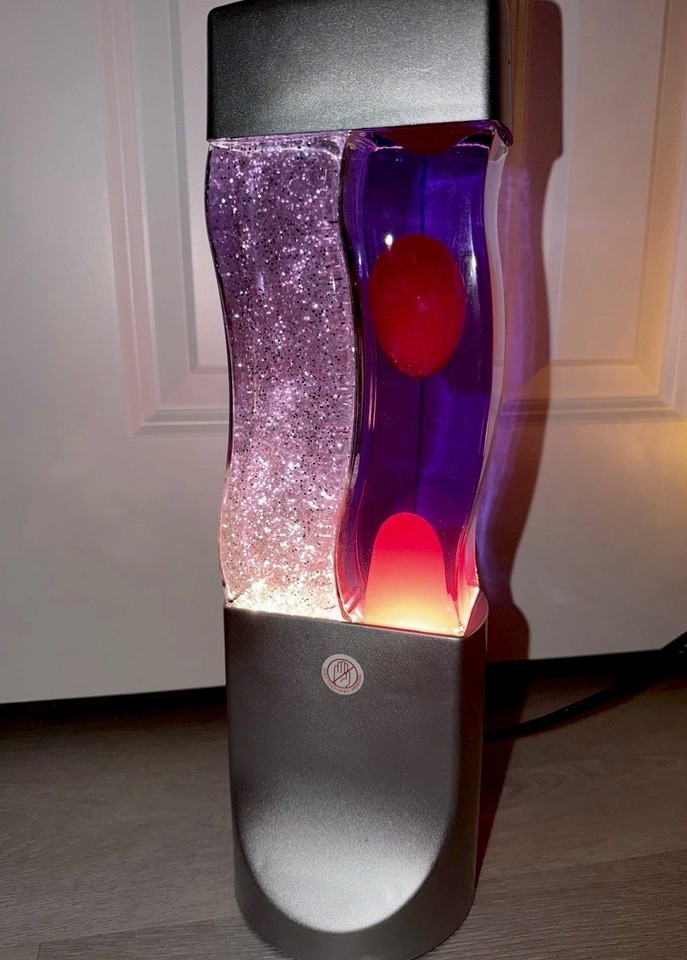 Twin-chamber wavy lava lamp in red and purple glitter stardust — two motions, zero chill, maximum vibe.