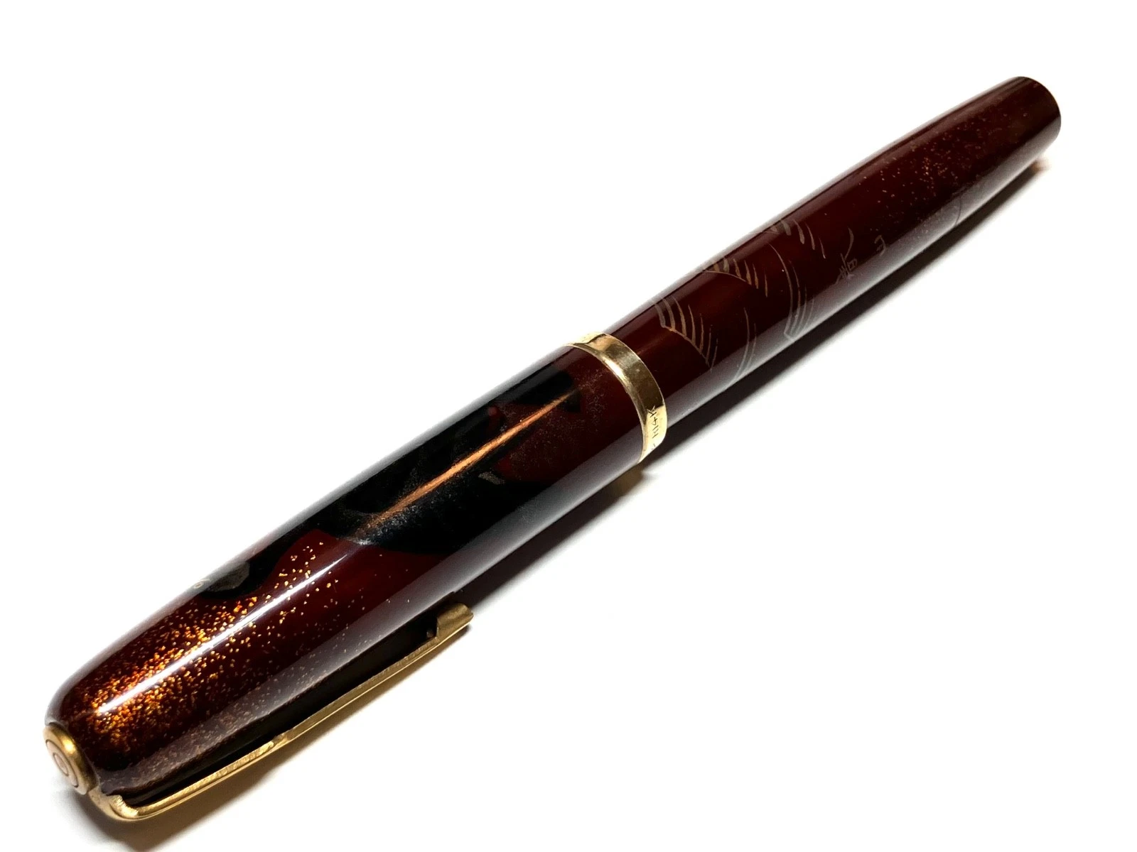 Vintage ink shut off fountain pen with gold nib, black body, and gold leaf pattern on paper, HARUYAMA made.