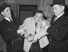 Actor Lino Venturo is held by two policeman filming a scene from f- Old Photo