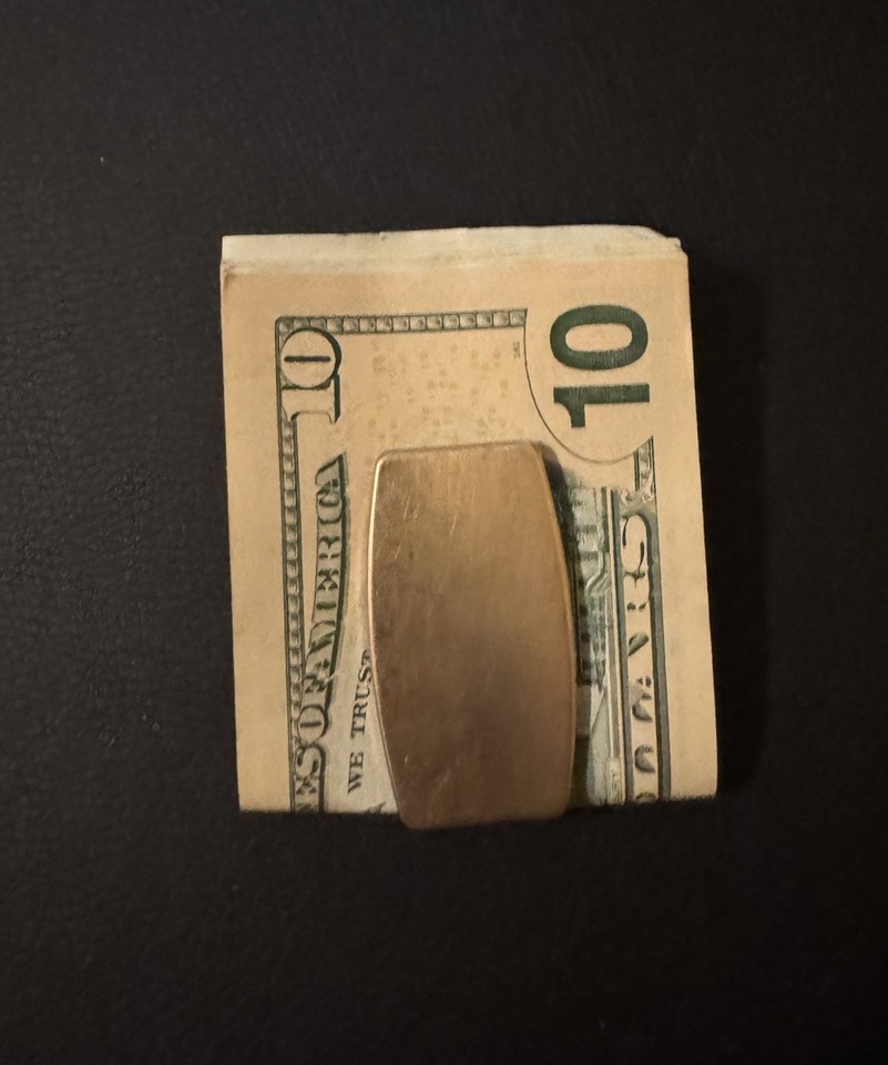 A vintage Zippo-branded gold-tone money clip that doubles as a knife and file — a forgotten pocket artifact that looks like it fell out of a 1960s gentleman's jacket.