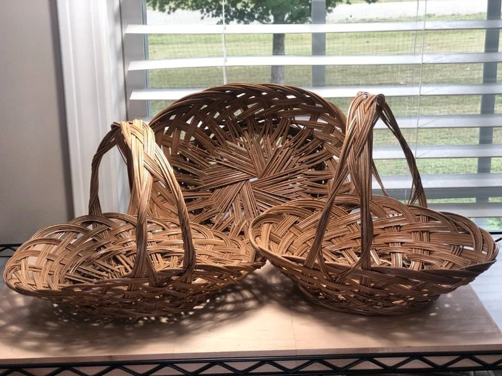 Set of three vintage handwoven rattan wicker baskets in cottage style.