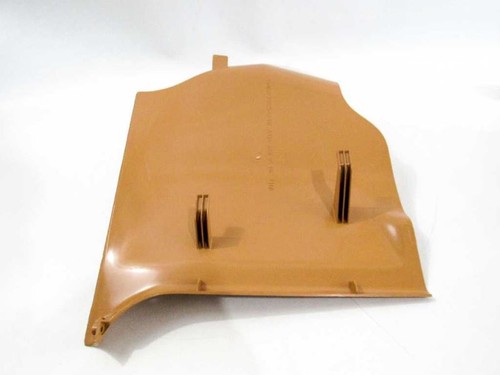 Tan 86-95 Mercedes W124 front right footwell lower paneling with two metal clips and embossed brand on white background.