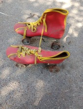 vintage Roller Derby brand quad skates in red with yellow trim and laces.