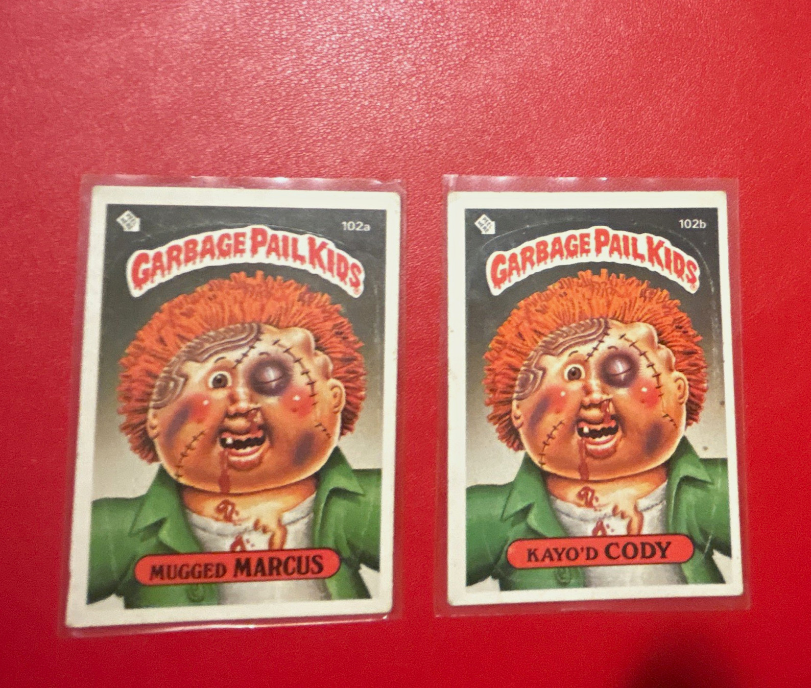 Topps 1986 Garbage Pail Kids 2-Card Lot #102a Mugged Marcus #102b KayO'd Cody