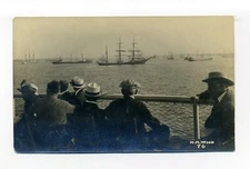 Men looking out over harbor full of ships, square rigged RPPC photo postcard
