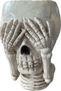 See No Evil" skull decoration features hands covering its eyes