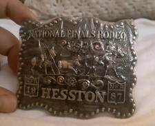 Vintage Hesston new National Finals Rodeo belt buckle. Gold tone. sealed